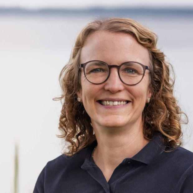 02. Eva Philipp Ärztin vor Wasser mit Brille und Lächeln bei Praxis am Glockenturm.