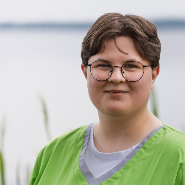 13. Theresa Timme Praxis am Glockenturm: Freundliche Mitarbeiterin vor Wasser im Hintergrund.